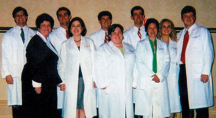 Ginnie is a very proud mom and mentor at the White Coat Ceremony in 2005. Her students from back left: William Payne, Chad Hosemann, Rob Marble, Calvin Thigpen, Vanessa Lackey, Brad Ingram. Front left to right: Ginnie, Margaret Edwards Wadsworth, Katie Taylor, Ginny Carroll.