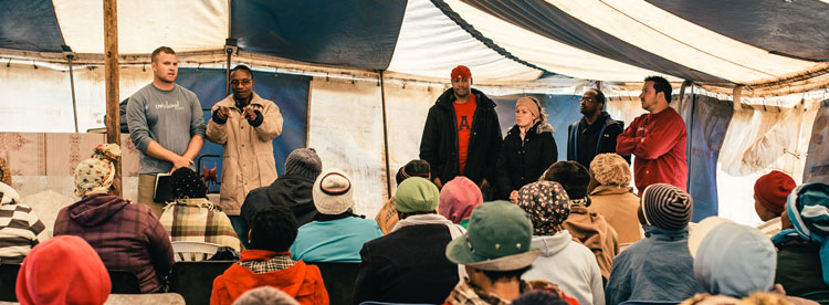 Brett Barnhill (far left) delivers the gospel with the help of an interpreter. Allison Hunter Barnhill (third from right) looks on and Jason Stoker (far right) watches. Notice the coats. It can get very cold in Lethoso and Botswana.
