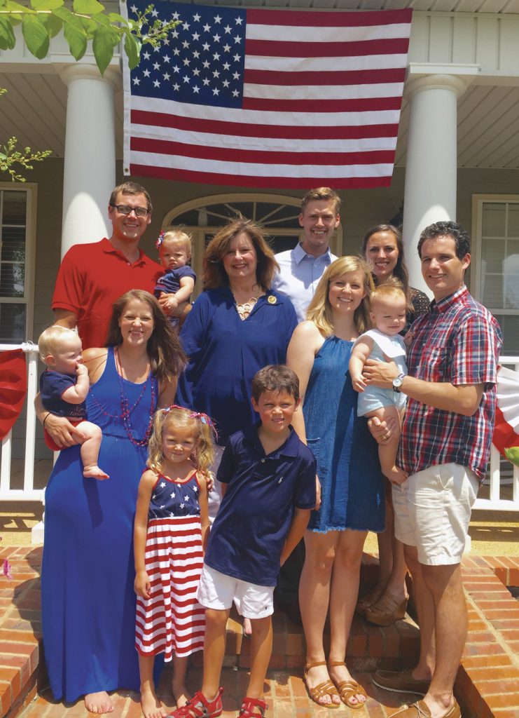 The Nunnelee’s Fourth of July celebration in 2016. (Back L to R) Reed holding his daughter, Jane Alan; Nathan and Colleen Nunnelee. (Center) Tori (Front L to R) Reed’s wife, Kemily, holding twin daughter, Lucy; Harper a,nd Thomas (Reed and Kemily’s daughter and son); Emily Nunnelee and husband Morris holding their son Mack. This just happened to be the day Nathan was commissioned as an officer in the U.S. Navy.